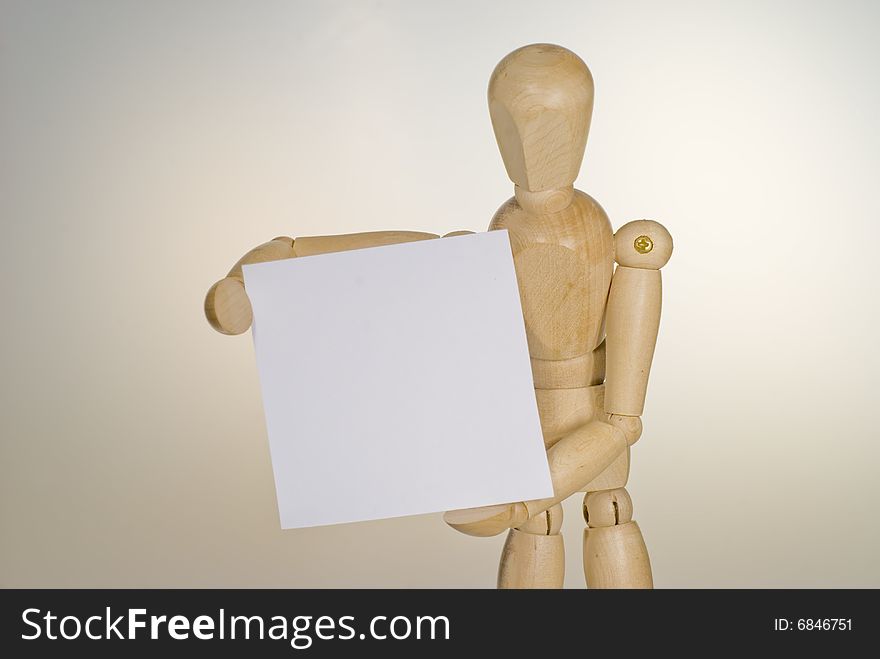 A shot of a wooden doll holding a sign. A shot of a wooden doll holding a sign