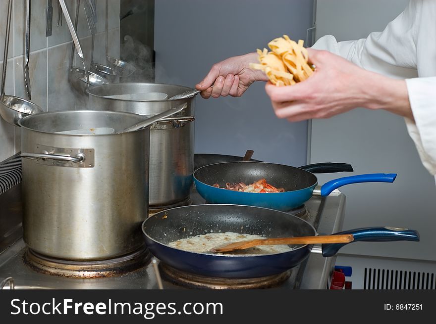 Noodles and sauce preparation, interior of Italian restaurant kitchen. Noodles and sauce preparation, interior of Italian restaurant kitchen