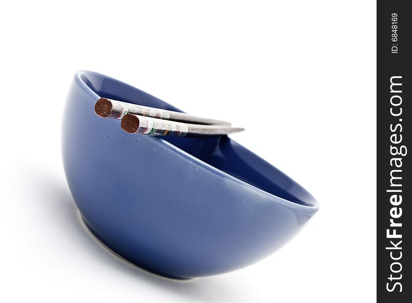 Wooden Chopsticks resting on a blue ceramic bowl. Wooden Chopsticks resting on a blue ceramic bowl
