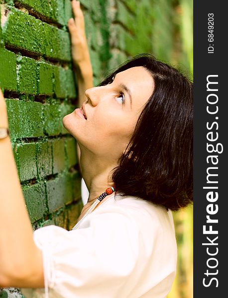 Woman leans on the green wall. Woman leans on the green wall