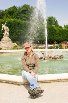 Girl Sitting Near A Fountain Royalty Free Stock Photography