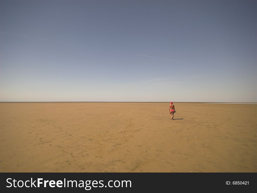 Beach Desert.
Woman walking on Koresand,  Low Tide Island in Denmark