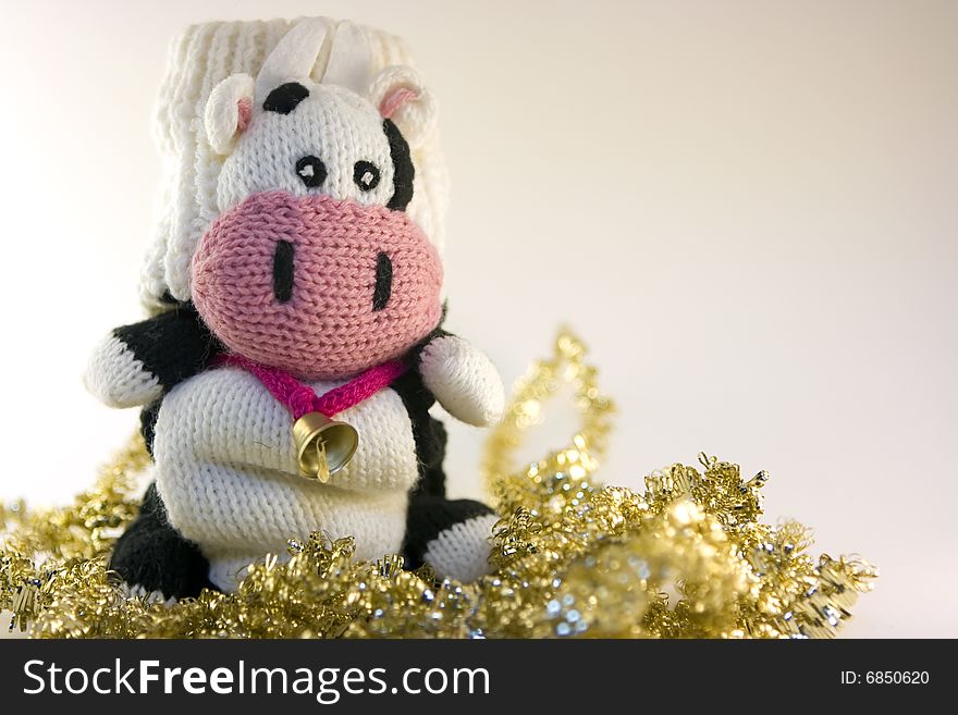 Mitten cow sitting on tinsels. Mitten cow sitting on tinsels