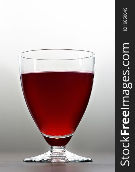 A glass of cherry juice. A glass of cherry juice.