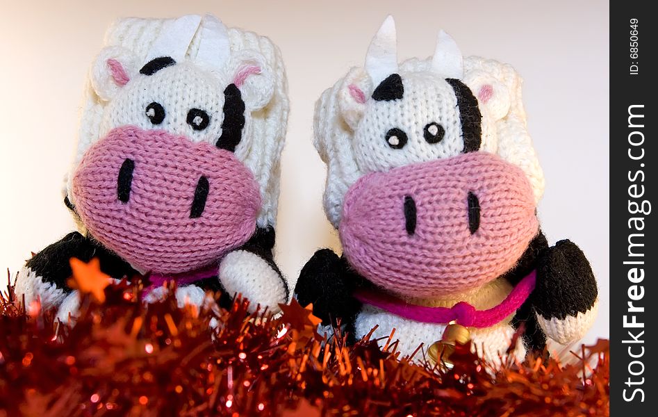 Mitten cows sitting on tinsels. Mitten cows sitting on tinsels