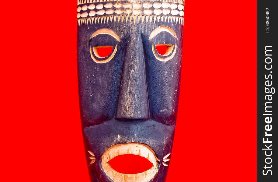 African style wooden mask isolated on red. African style wooden mask isolated on red