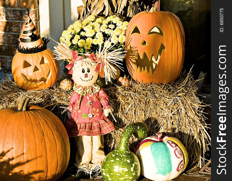 Fall display of a scarecrow, pumpkins and gourds