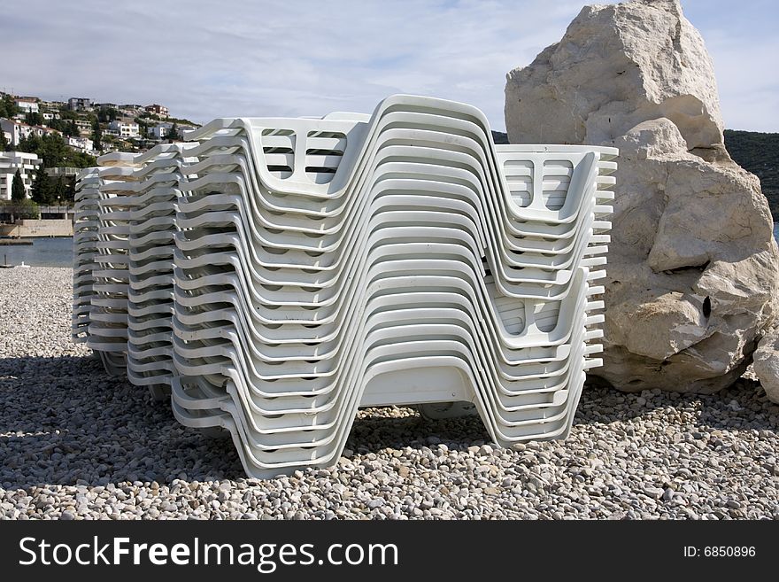 After season on the beach, pile of deckchairs