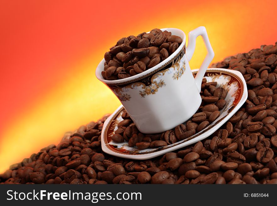 Traditional Turkish Coffee in ornamented traditional cup on a pile of coffee beans.