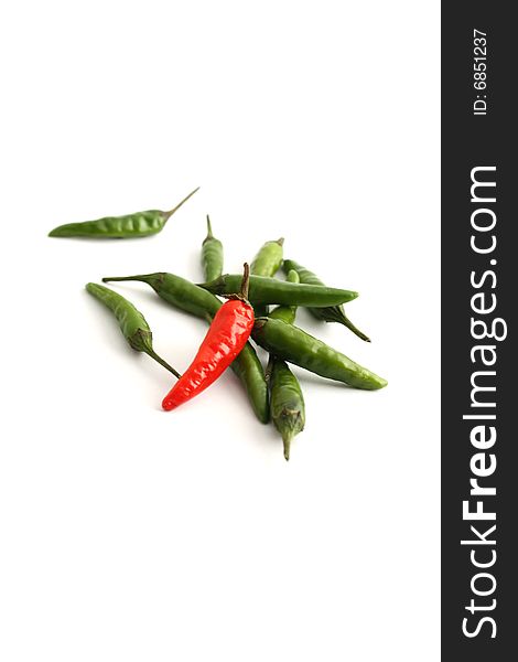 Green and red chilis on a white background