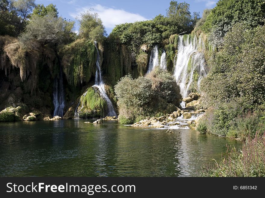 Wild, waterfall bay surrounded by trees and rocks