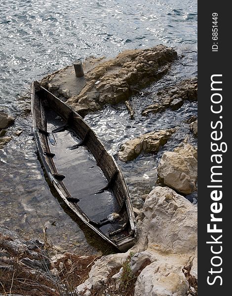 Sunken, old boat at the rocky shore. Sunken, old boat at the rocky shore