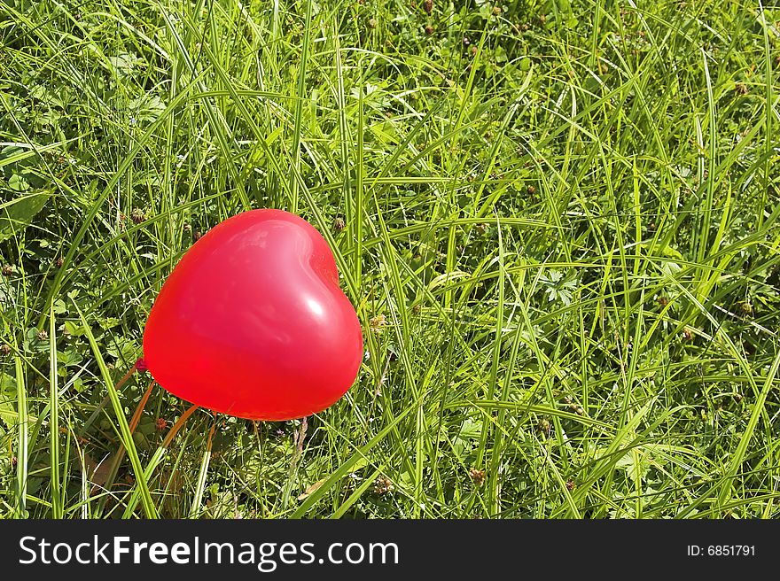 Red balloon in a green grass. Red balloon in a green grass