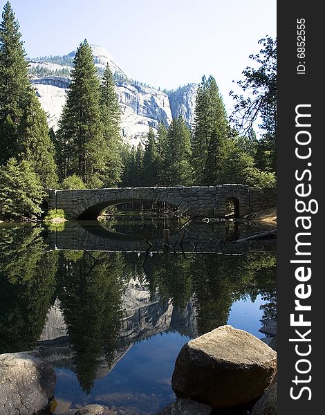 A bridge and nature reflects in the water. A bridge and nature reflects in the water