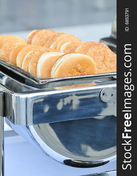 Sesame buns for burgers served in a catering dish. Sesame buns for burgers served in a catering dish