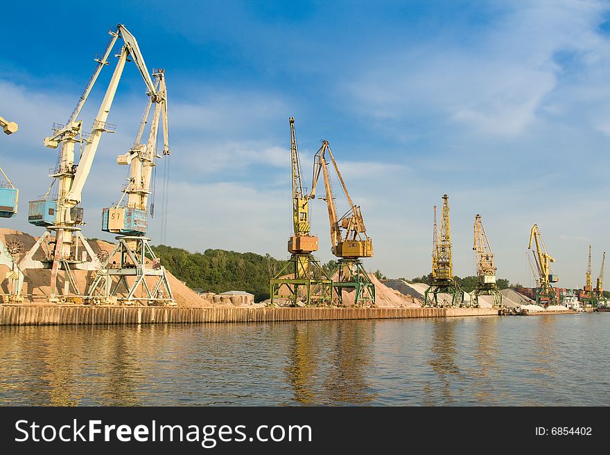 Port on river with cargo cranes. Port on river with cargo cranes