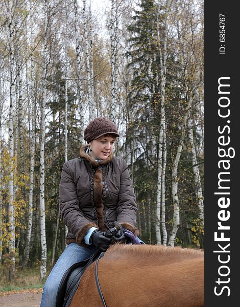 The horsewoman on ride in forest, autumn