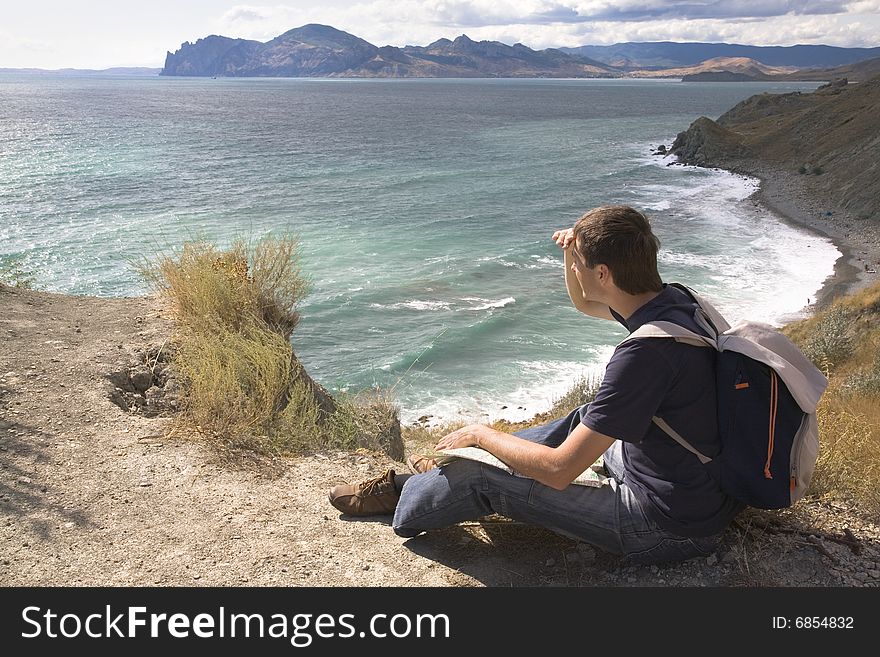 Man with backpack and map in a mountain. Man with backpack and map in a mountain