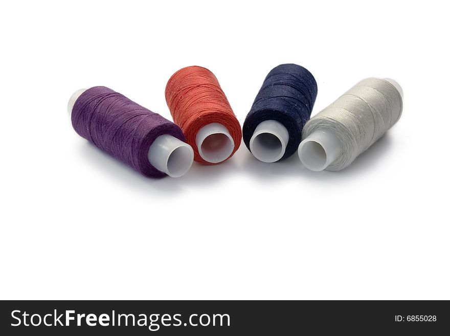 4 spools of the varicoloured threads on white background. 4 spools of the varicoloured threads on white background