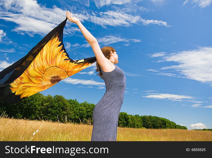 Beautiful woman with orange scarf in a meadow field