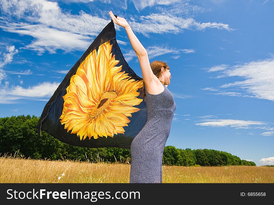 Beautiful woman with orange scarf in a meadow field