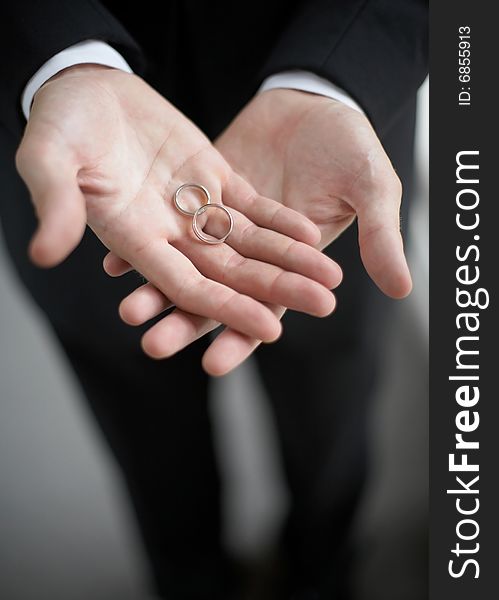 Hands holding wedding bands DOF focus on rings. Hands holding wedding bands DOF focus on rings