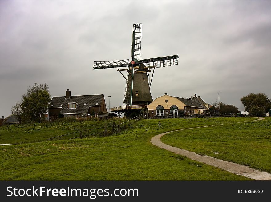 Dutch windmill with stormy, moody skies. Beggining of autumn. Dutch windmill with stormy, moody skies. Beggining of autumn.