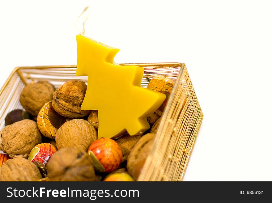 Walnuts, sweets and handmade candle in a basket