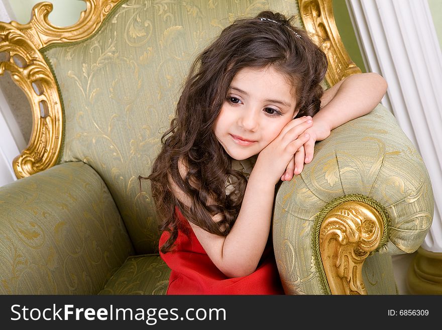 Small girl with long hair in the armchair. Small girl with long hair in the armchair