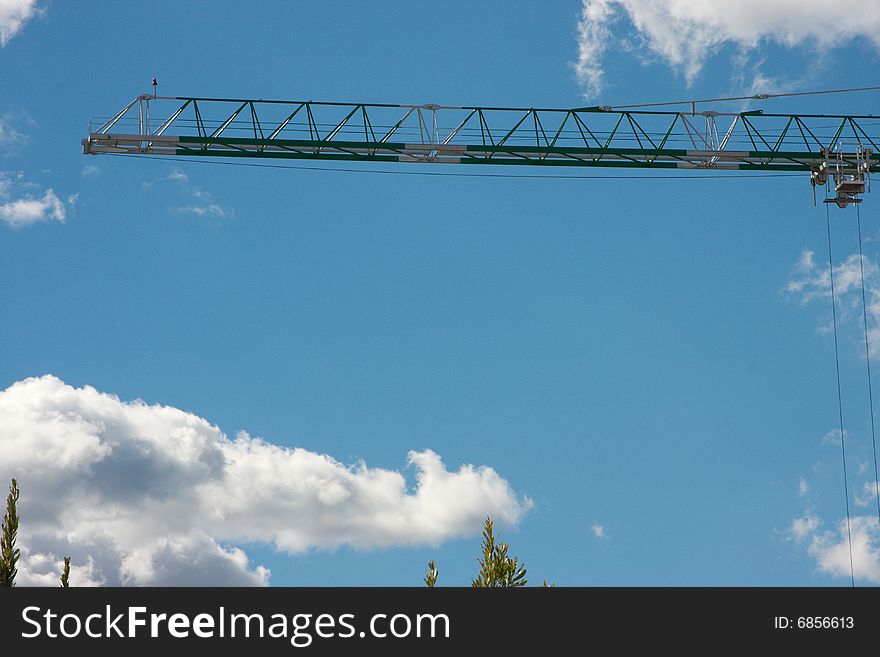 Construction crane on the blue sky