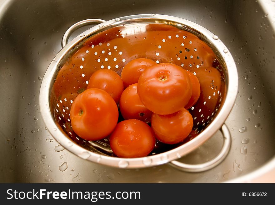 Fresh tomatos in silver strainer