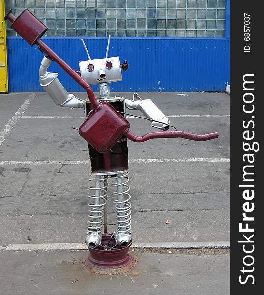 Funny figured looking like robot is made from details of the machines, advertises workshops. Funny figured looking like robot is made from details of the machines, advertises workshops