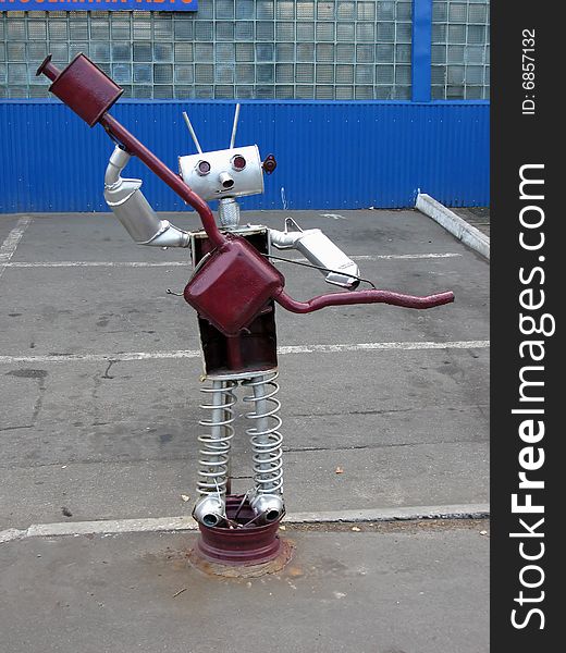 Funny figured looking like robot is made from details of the machines, advertises workshops. Funny figured looking like robot is made from details of the machines, advertises workshops