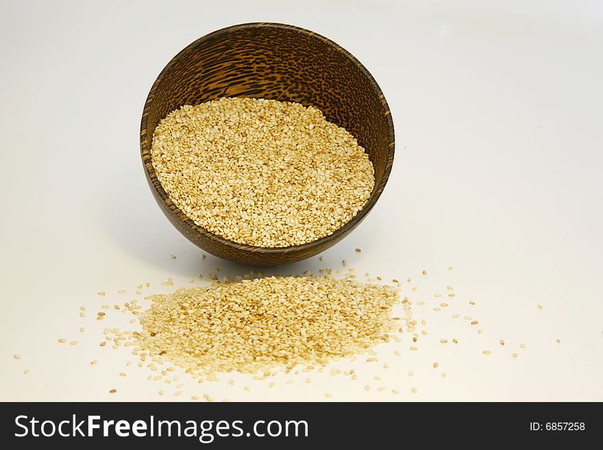 Sesame seeds in coconut bowl isolated on white background. Sesame seeds in coconut bowl isolated on white background
