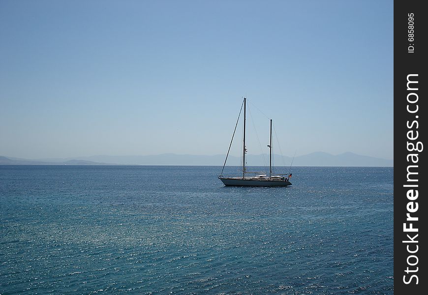 Small boat anchored in a gulf of a Mediterranean coast of Turkey on a perfect summer day. Small boat anchored in a gulf of a Mediterranean coast of Turkey on a perfect summer day