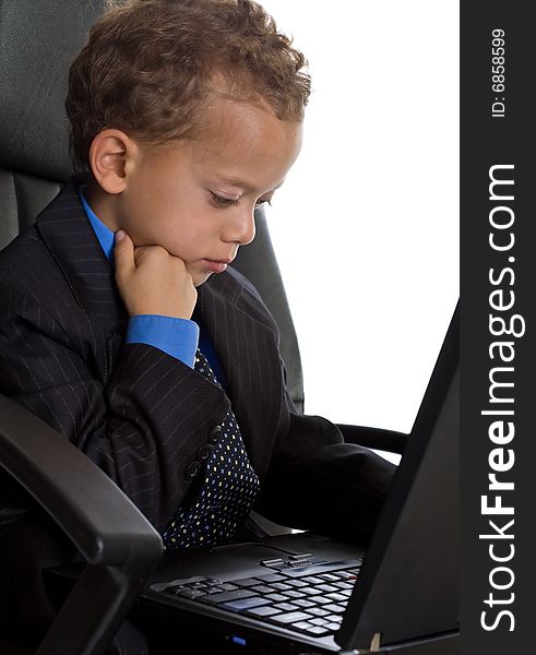Young boy dressed as businessman with laptop