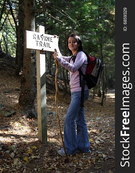 Pretty Teenage Hiker Leaning Against A Sign Post