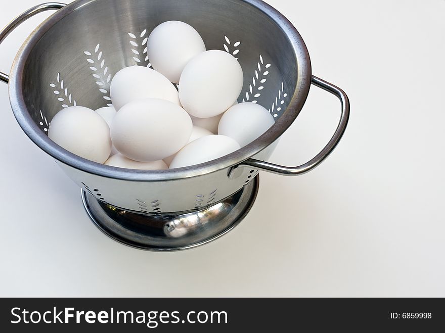 Stainless steel colander with white eggs. Stainless steel colander with white eggs.
