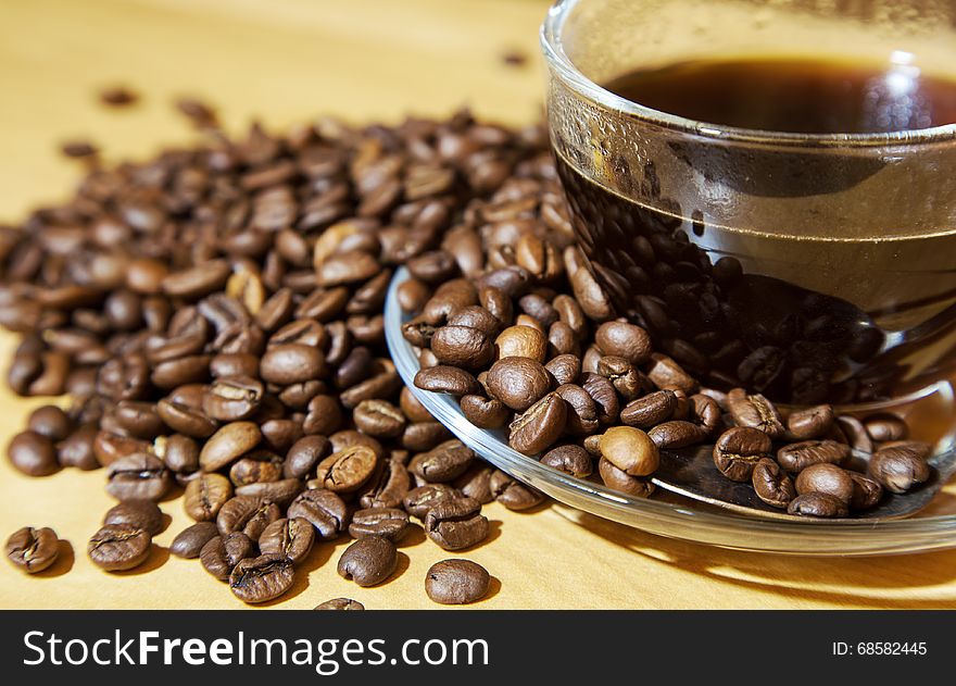 Coffee beans and a cup of coffee on the table closeup. Coffee beans and a cup of coffee on the table closeup