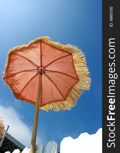 Orange umbrella on the beach and windy weather