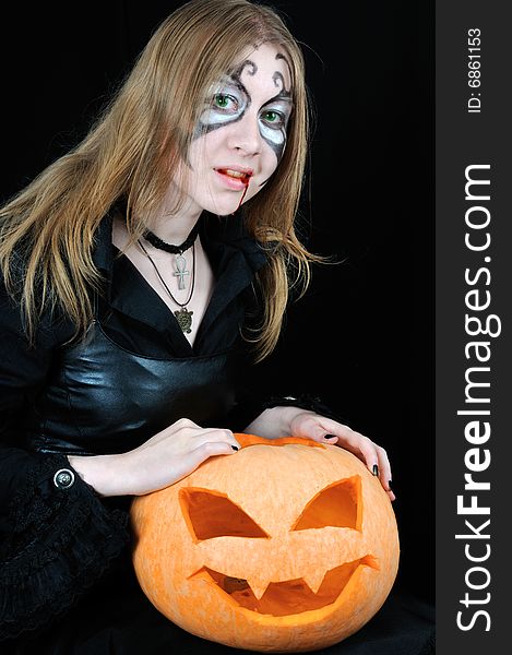 Halloween bloody vampire with pumpkin, on black background