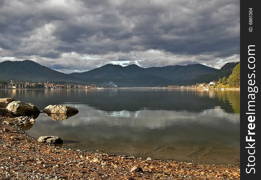 Coastline lake Teletskoe and cloudscape.