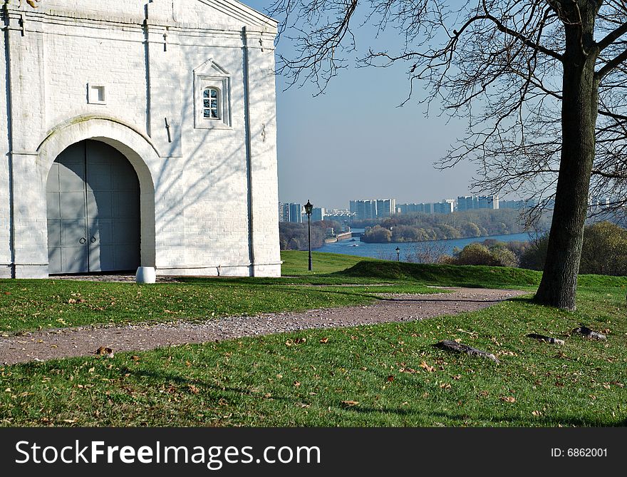 On river bank the fragment of an ancient building, on a background residential buildings is visible