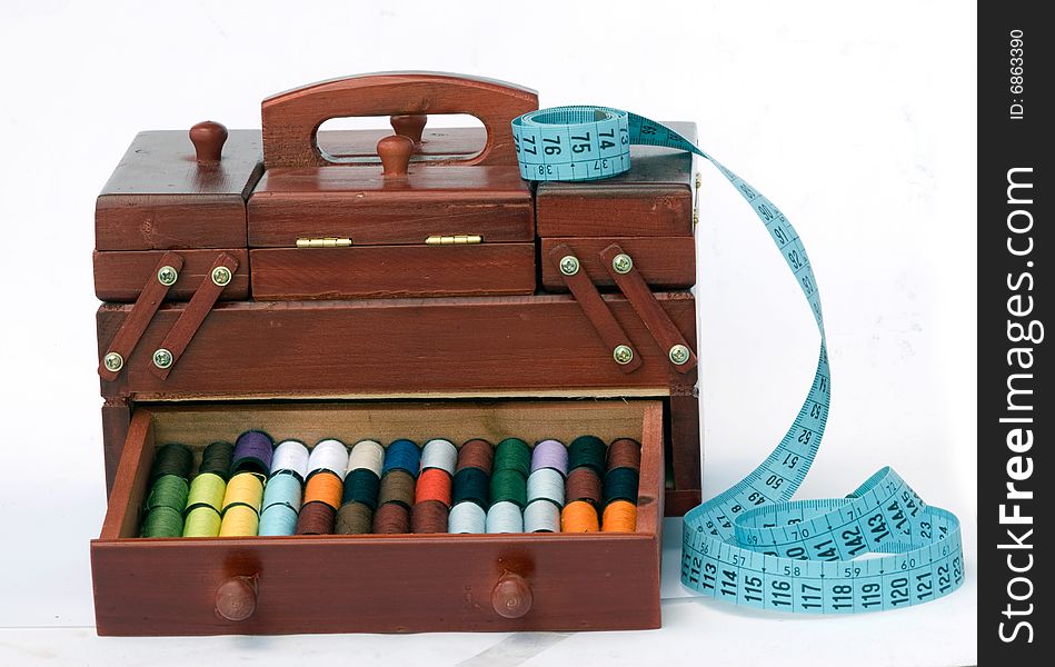 Wooden drawers with spools of colorful threads and measuring tape. Wooden drawers with spools of colorful threads and measuring tape