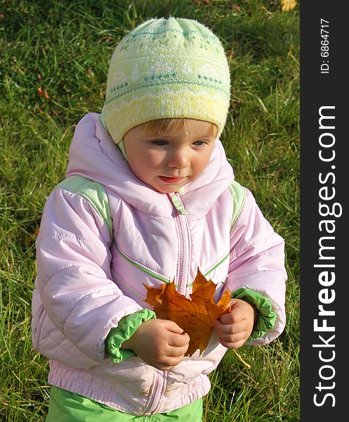 Little girl with yellow maple-leaf is smiling. Little girl with yellow maple-leaf is smiling