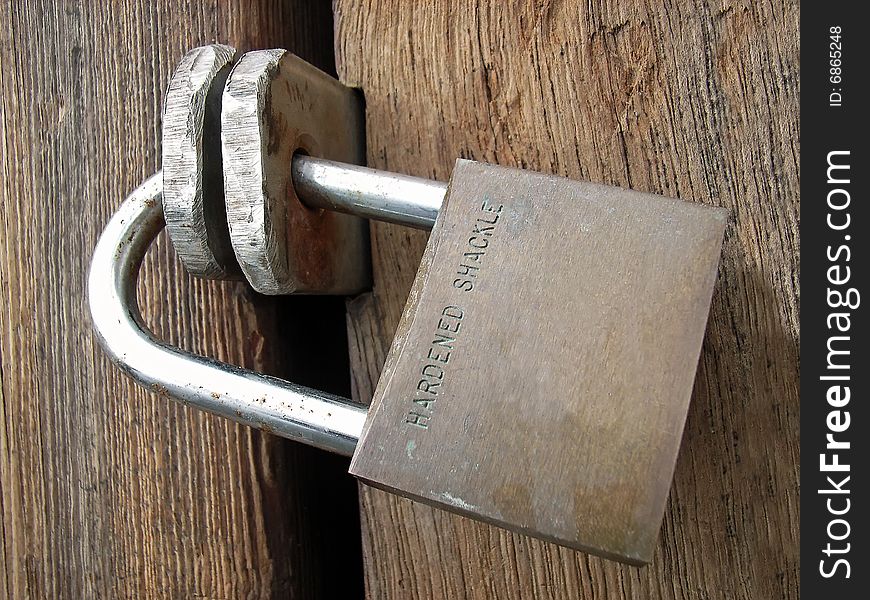 Padlock closing a wooden door. Padlock closing a wooden door