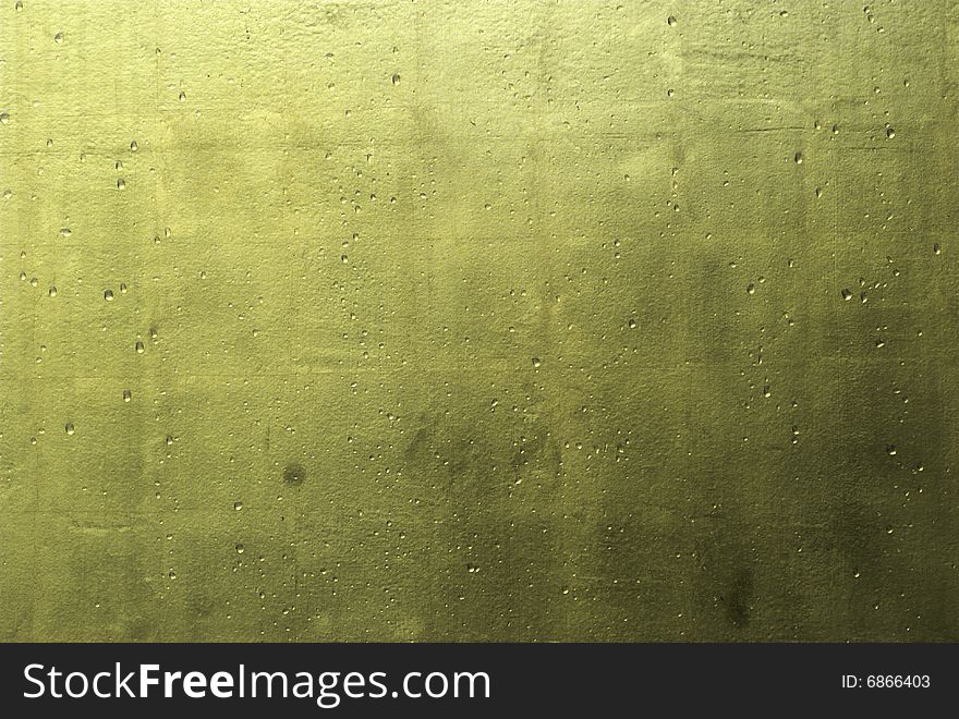 A gold painted wall with raindrops and realistic gold color texture. A gold painted wall with raindrops and realistic gold color texture