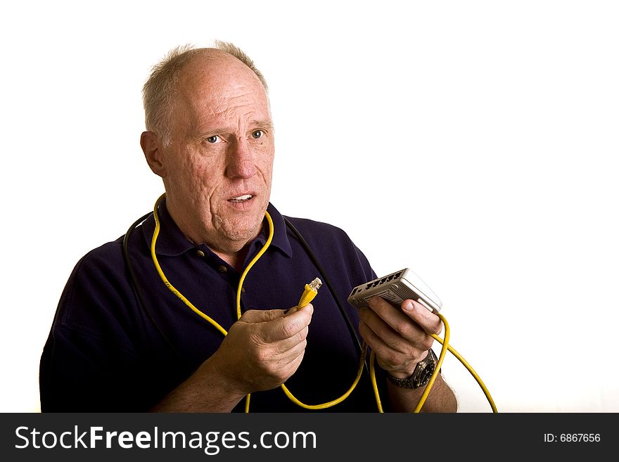 An old guy trying to figure out how to plug in a network cable to a switch. An old guy trying to figure out how to plug in a network cable to a switch