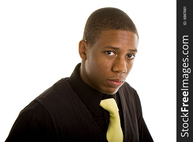 A young black man in black shirt and yellow tie with a serious expression. A young black man in black shirt and yellow tie with a serious expression