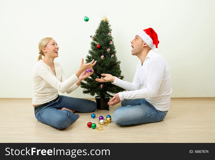 The pair juggles with spheres sitting at a Christmas pine. The pair juggles with spheres sitting at a Christmas pine